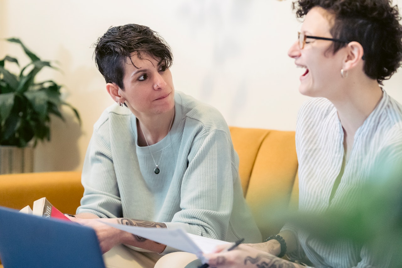 coach-talking-to-client-while-using-laptops-on-coworking-space-professional-coaching